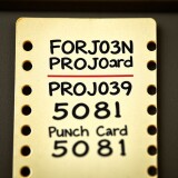 A-close-up-comical-depiction-of-a-vintage-punched-card-labeled-Fortran-Card-PROJ039-and-Punch-Card-5081.-The-image-centers-entirely-on-the-card-highlighting-its-unique-perforations-and-text