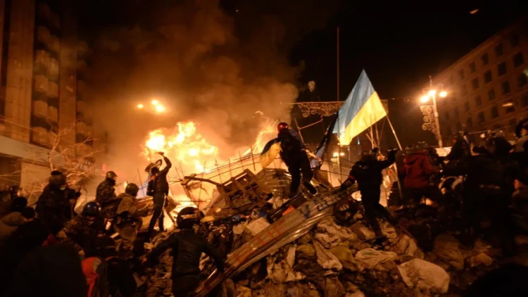 sstate-flag-of-ukraine-carried-by-a-protester-to-the-heart-of-developing-clashes-in-kyiv-ukraine-events-of-february-18-2014.webp