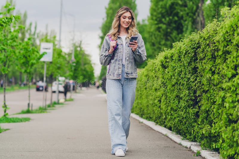 full-body-portrait-pretty-young-girl-use-phone-backpack-wear-denim-jacket-walk-street-outdoors-335569998.jpg