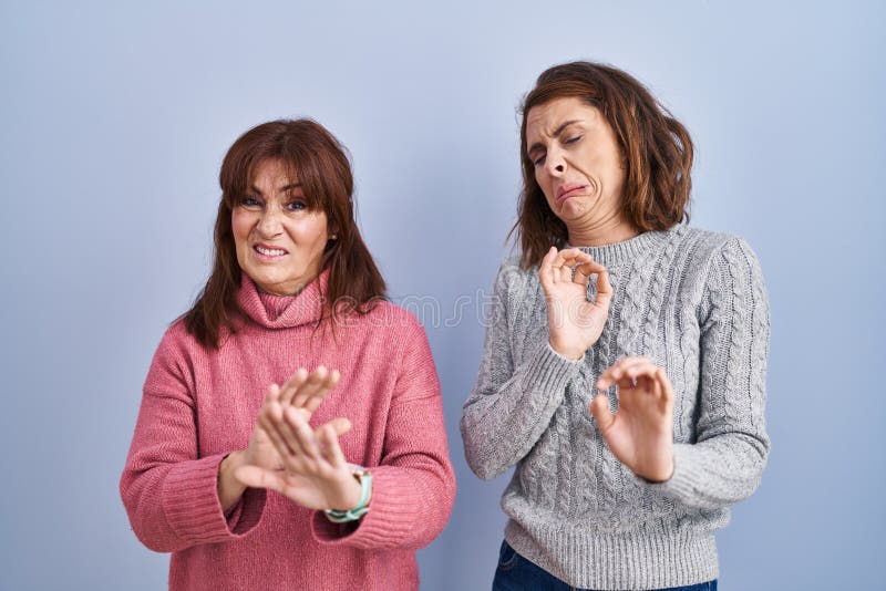mother-daughter-standing-over-blue-background-disgusted-expression-displeased-fearful-doing-disgust-face-aversion-266507850.jpg